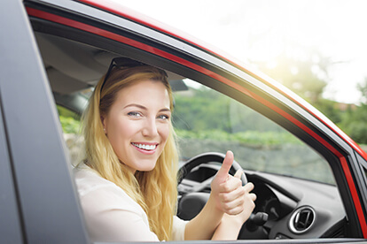 woman-in-driving-seat-with-thumbs-up